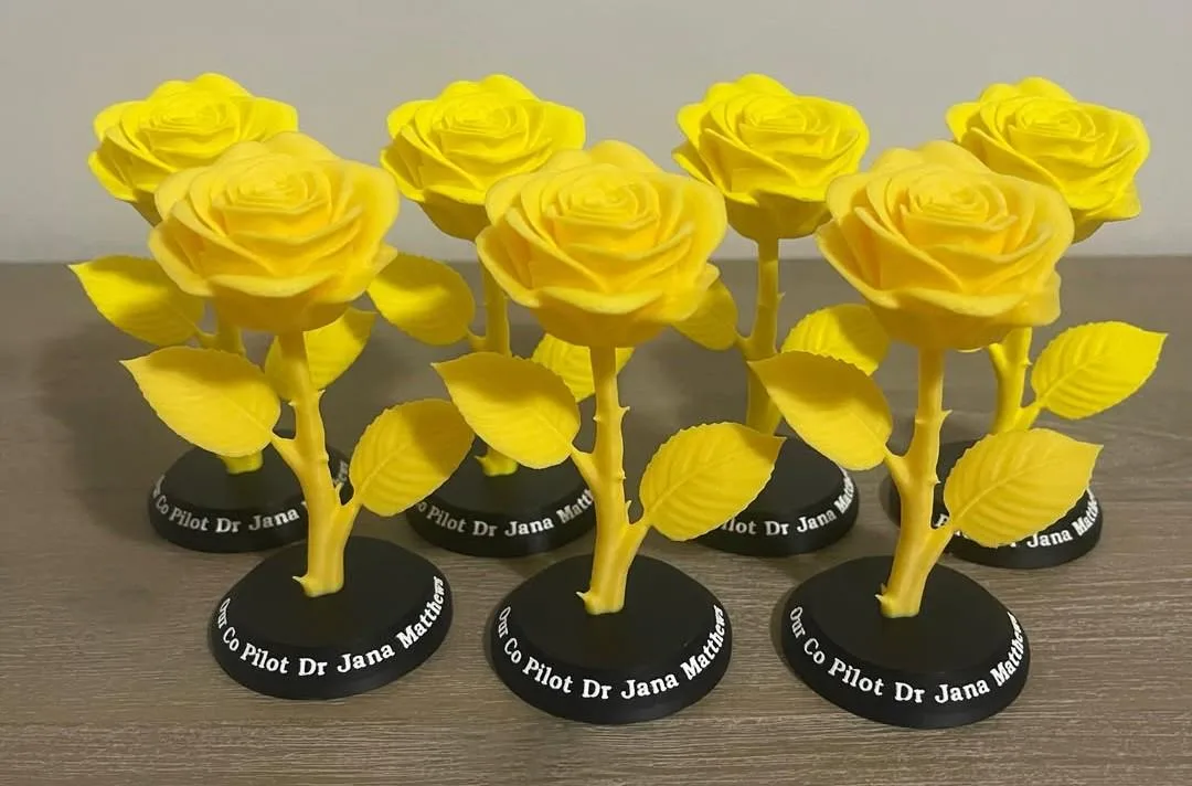 Yellow rose sculptures on black bases cut with a personalised inscription
