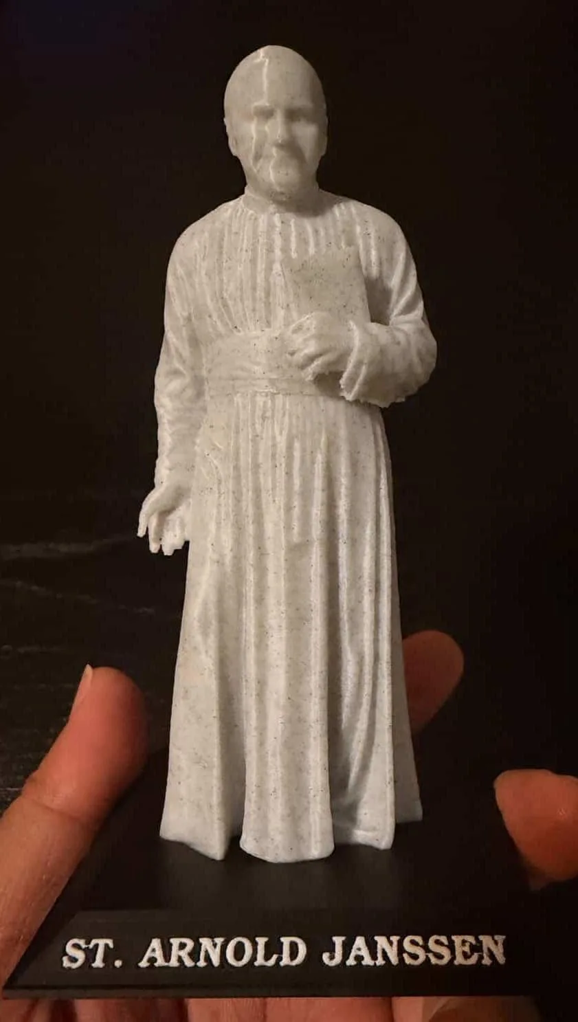Saint Arnold Janssen statue in speckled marble on an inscribed base