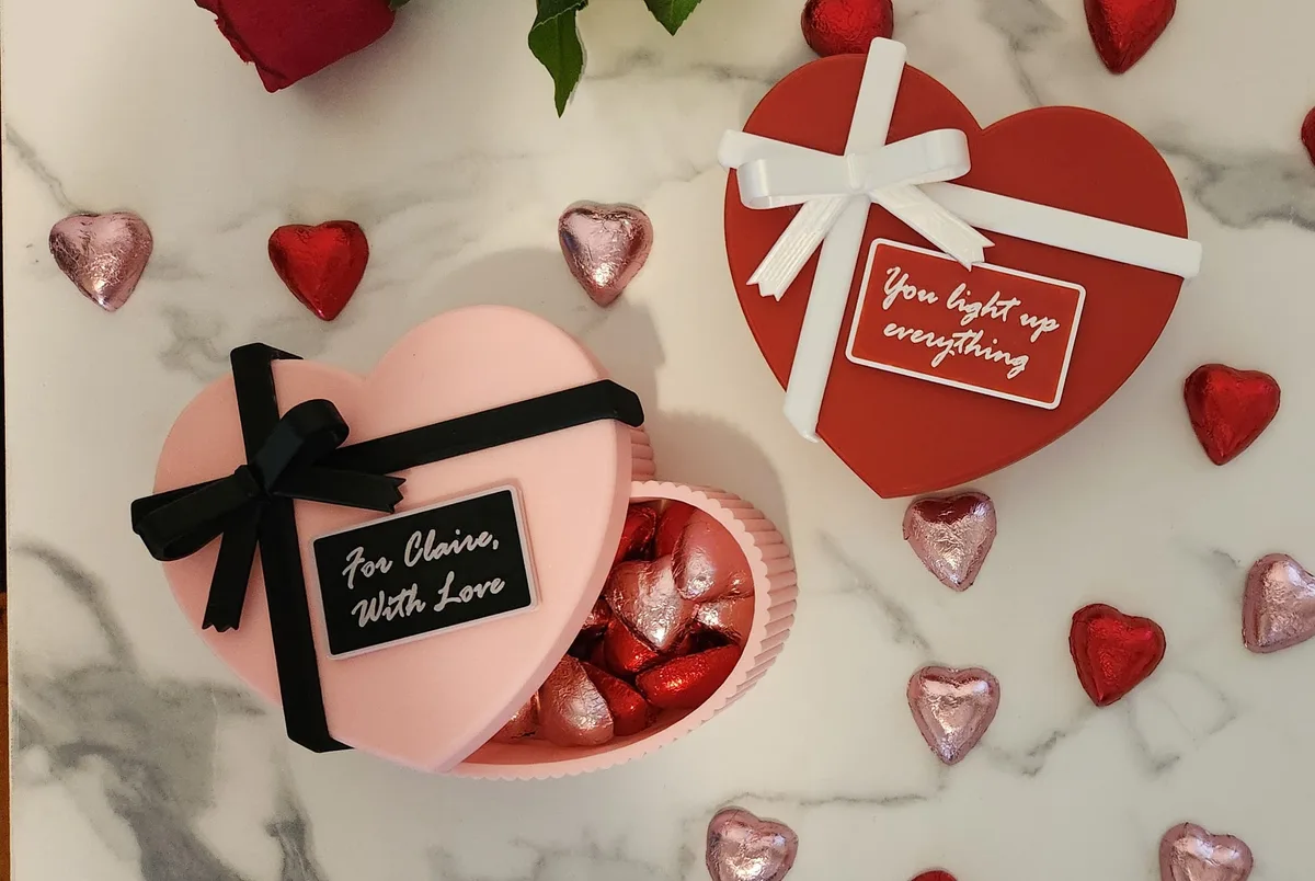 Pink and red heart-shaped gift boxes with ribbons and message plaques